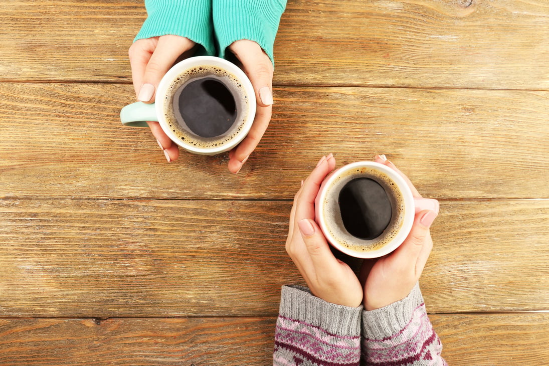 Two Women Holding Cups of Coffee