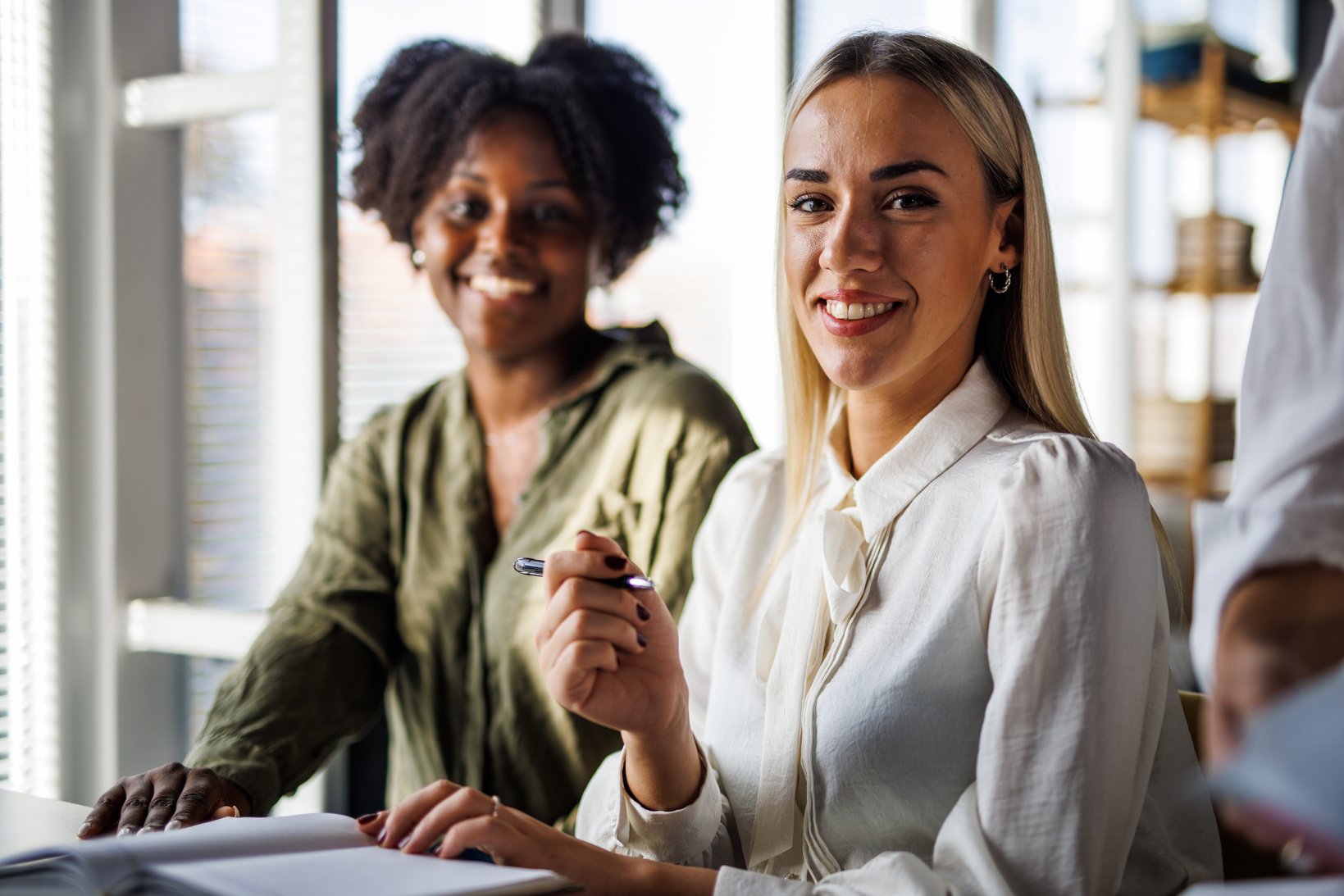 Two businesswomen going over their notes when working on a project together